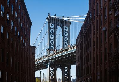 Manhattan bridge from between two buildings